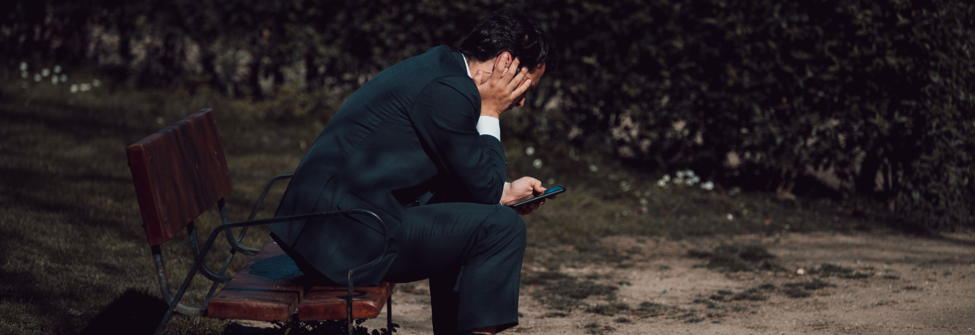stress worker in park looking at phone